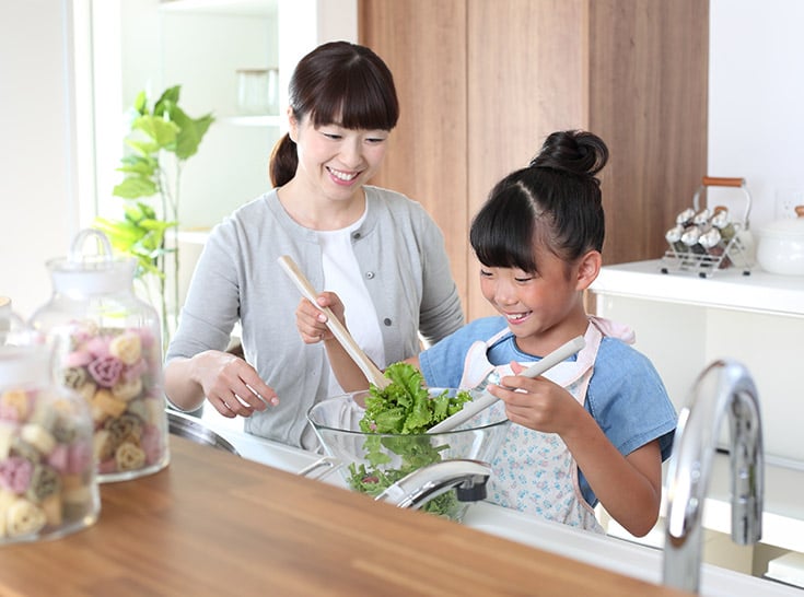 一戸建て住宅のキッチンで料理を楽しむ親子