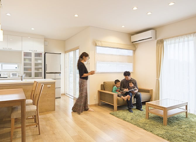 一戸建て住宅のリビングでくつろぐ家族